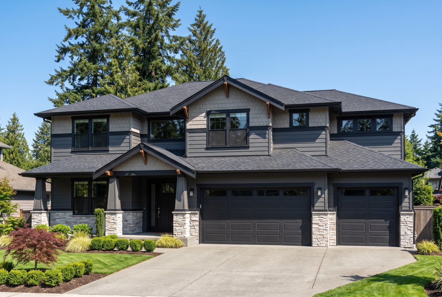 Completed residential reroof with a new charcoal architectural asphalt shingle roof on a large two-story Greater Seattle home, seen from the driveway