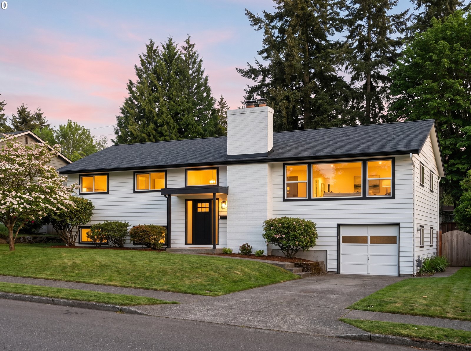 New charcoal shingle roof on a white mid-century split-level home in a mature Seattle neighborhood, seen from the street at dusk